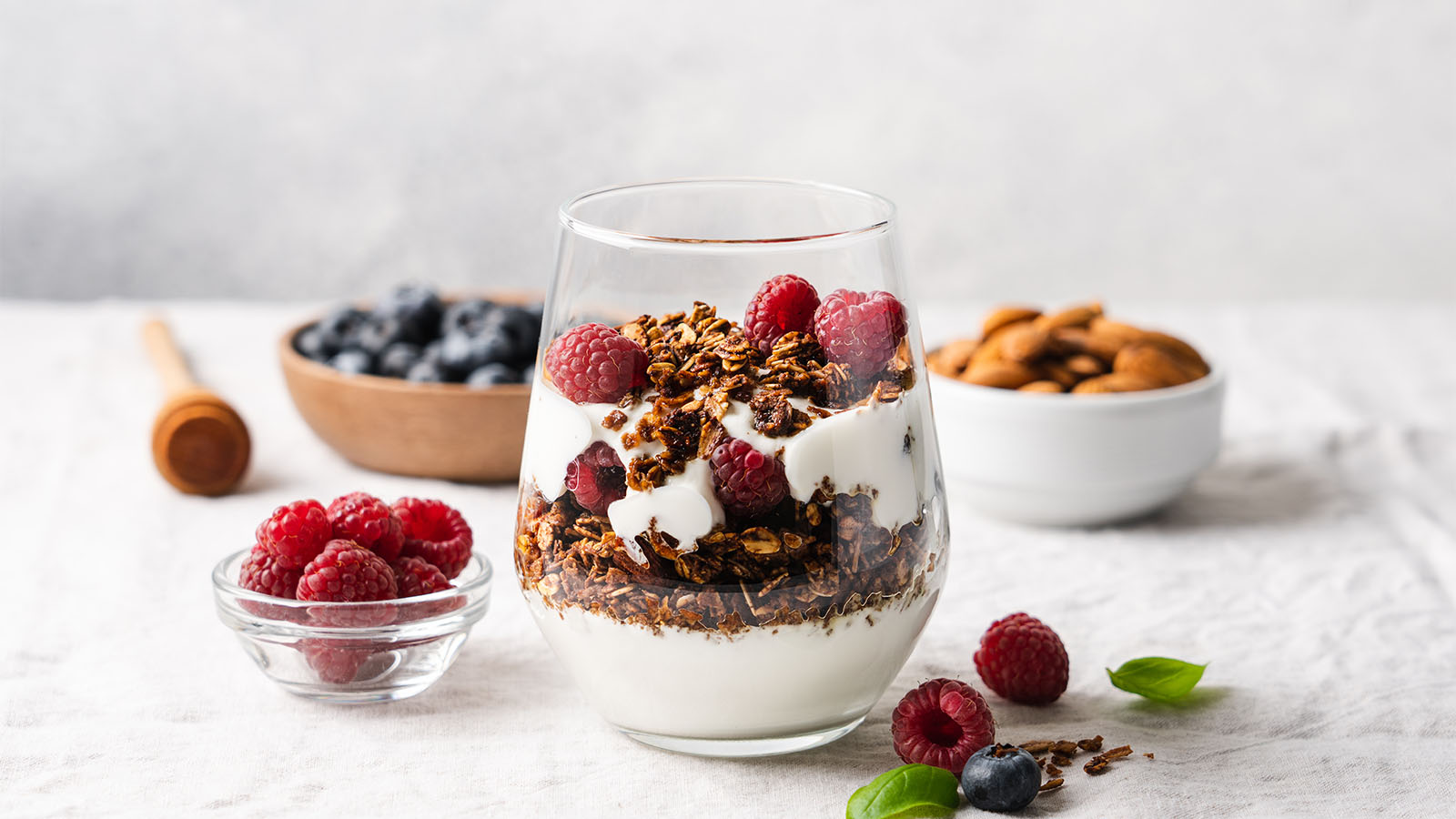 A healthy breakfast glass parfait layered with granola, yogurt, and fresh mixed fruits.