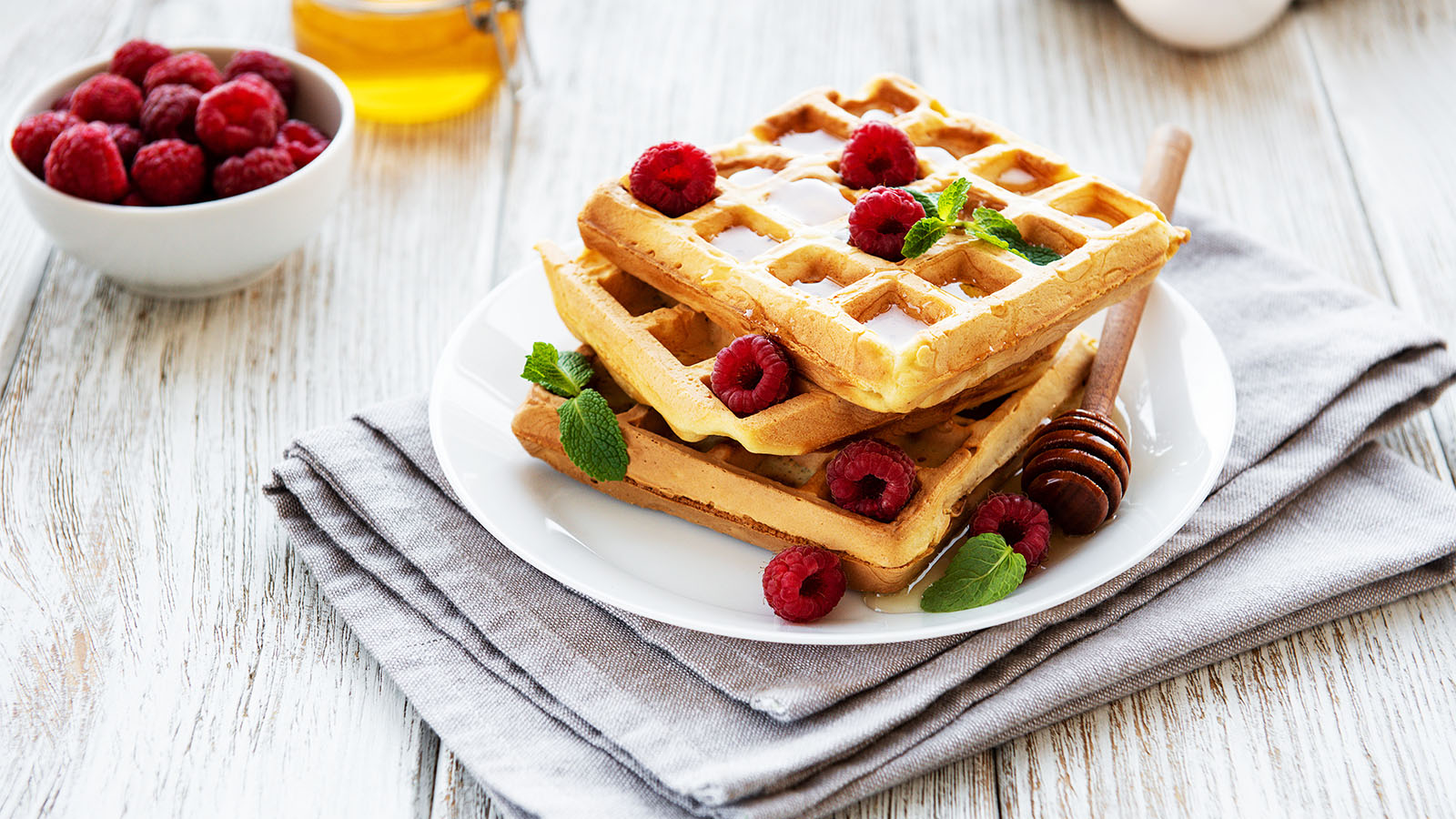 A crispy golden breakfast waffle topped with a vibrant assortment of fresh mixed fruits.