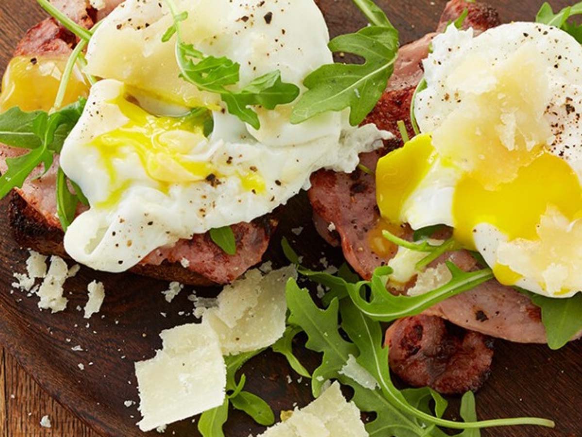 A buttery split croissant filled with crispy bacon, melted mozzarella, and a poached egg.