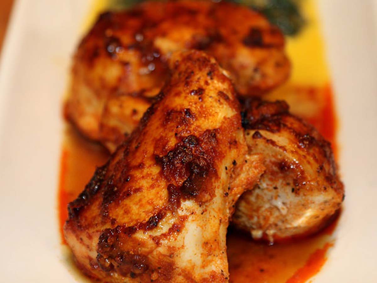 Tender chicken pieces marinating in a red, savoury overnight paprika chicken marinade spice.